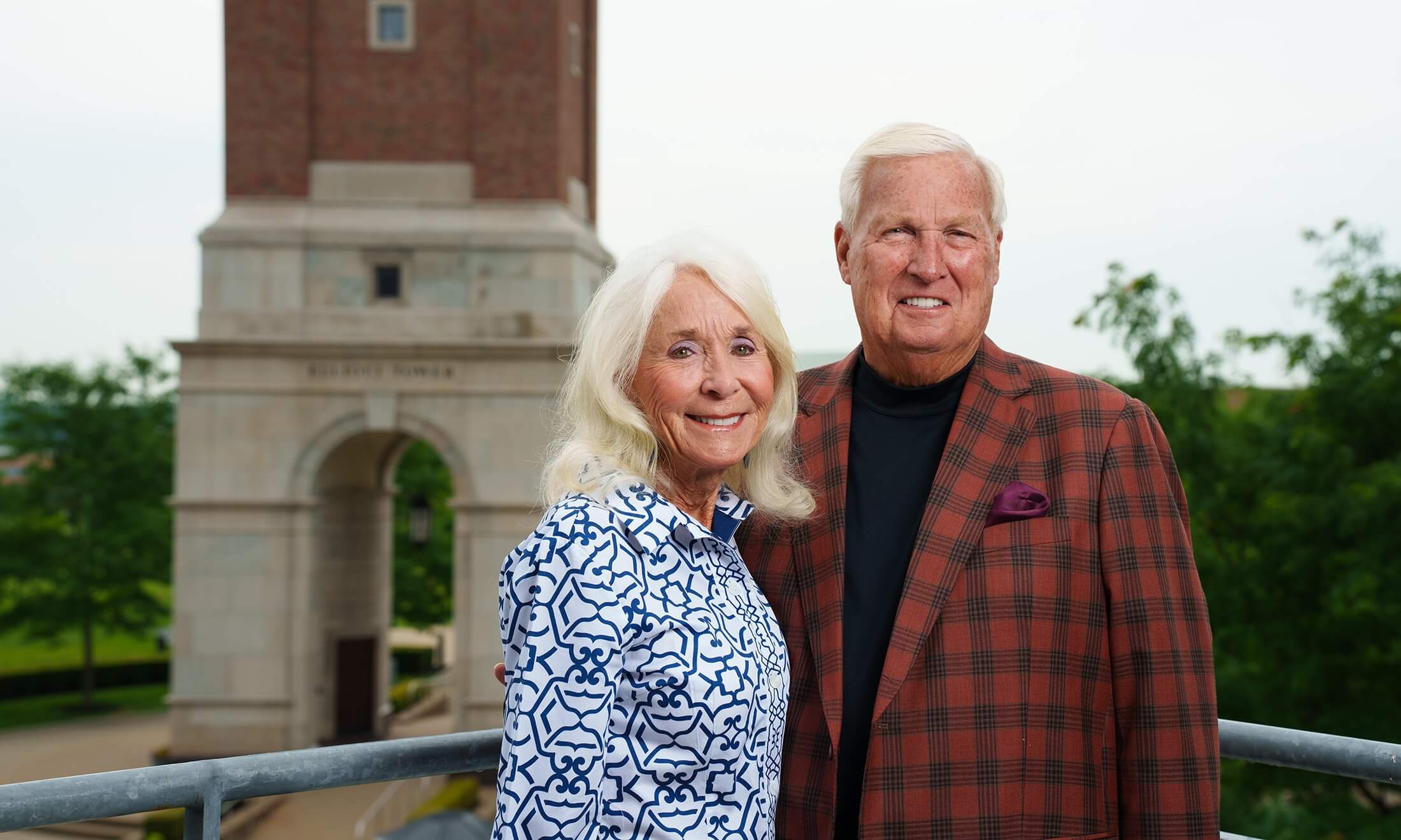 Hugh and Nancy Elliott stand next to each other in front of Elliott Tower