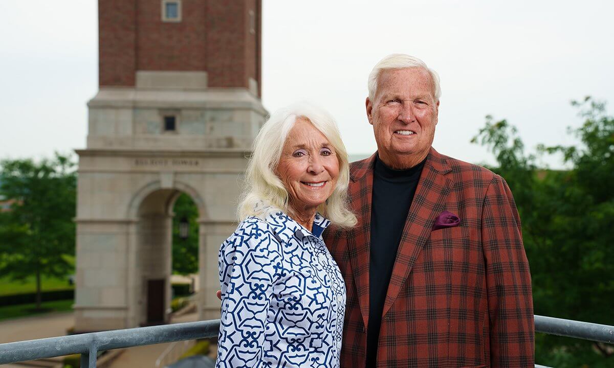 Hugh and Nancy Elliott stand together in front of Elliott Tower