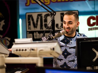 Man in a radio studio talking into a microphone