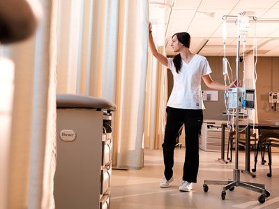 Female nurse closing a curtain in a hopsital setting
