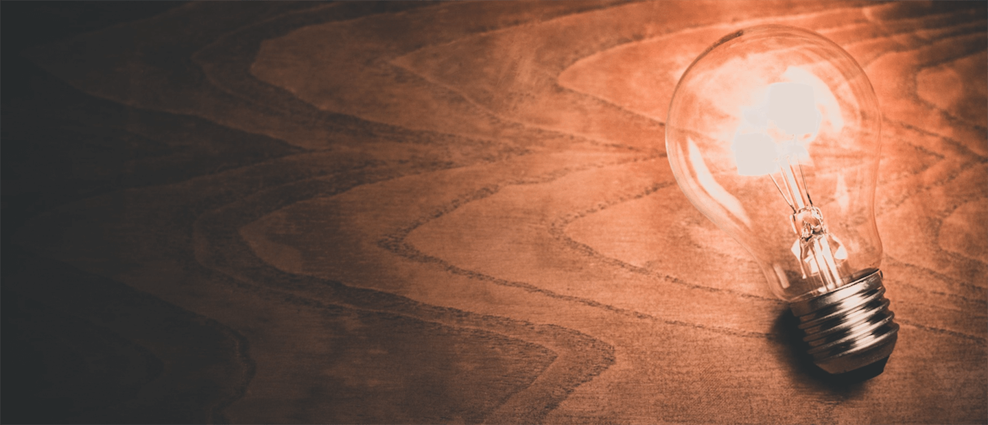 A lightbulb emitting light, laying on a desk