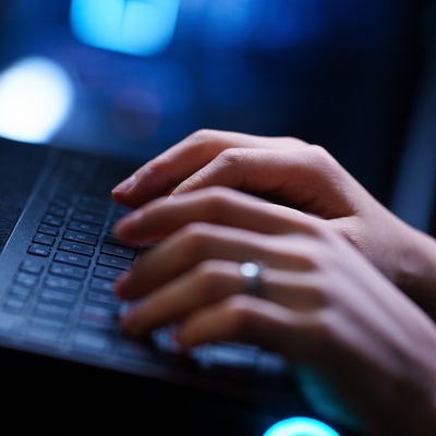 A closeup of hands on a keyboard.