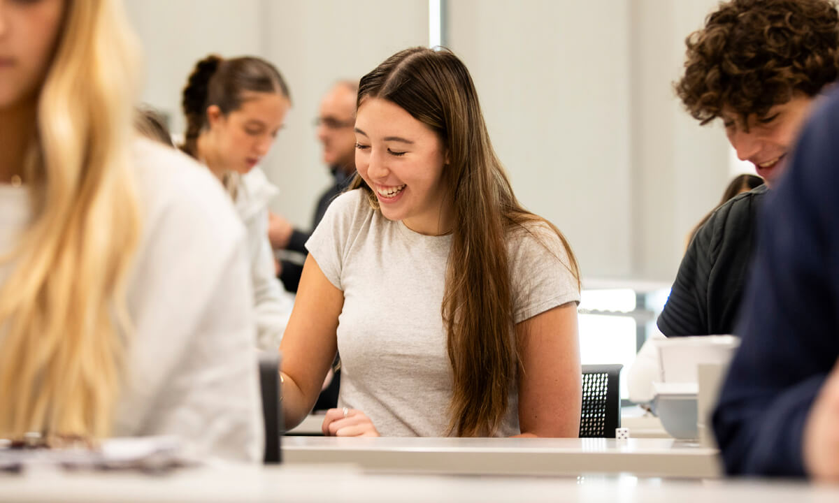 High school student smiling at a desk