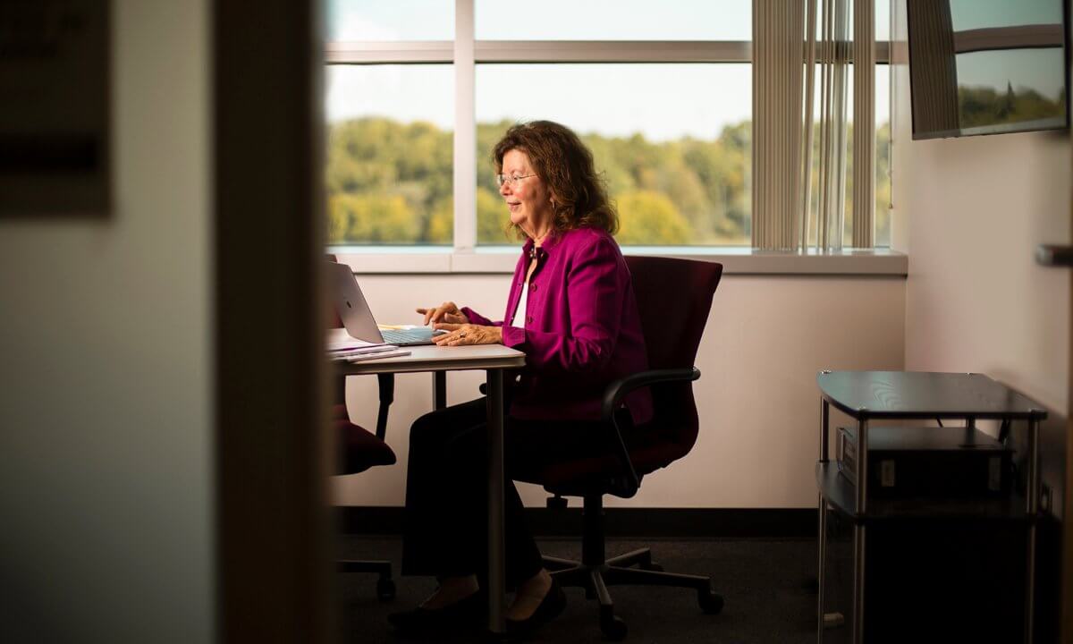 A woman works at a desk in an office.