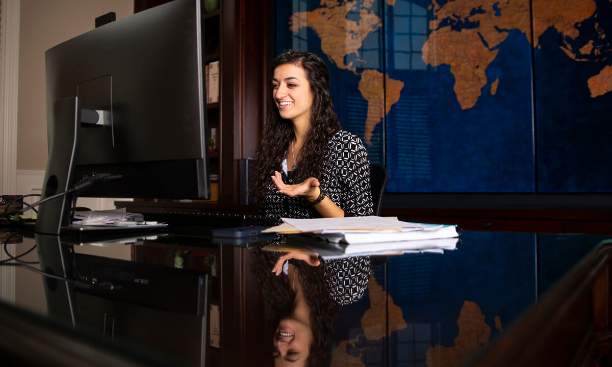 Image of a young girl sitting at a desk smiling.