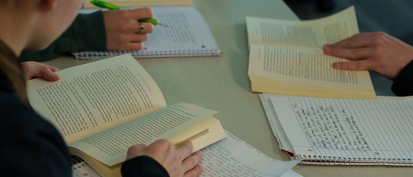 Multiple books are seen as people hold them open and take notes.