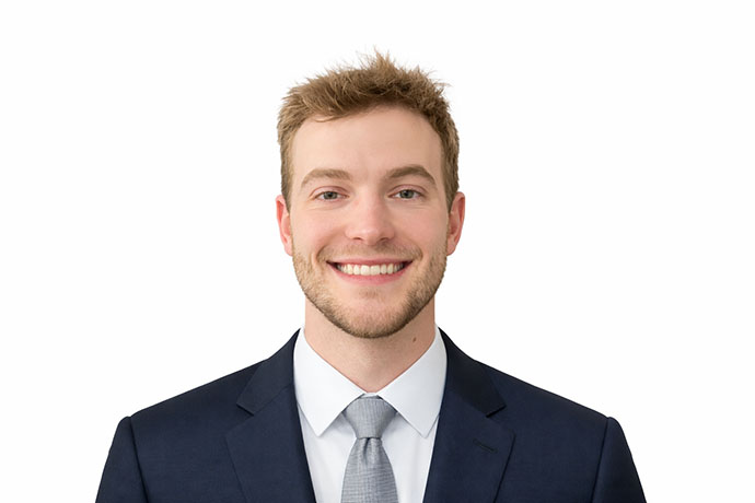 Brandon Owens poses for a photo in a suit and tie.