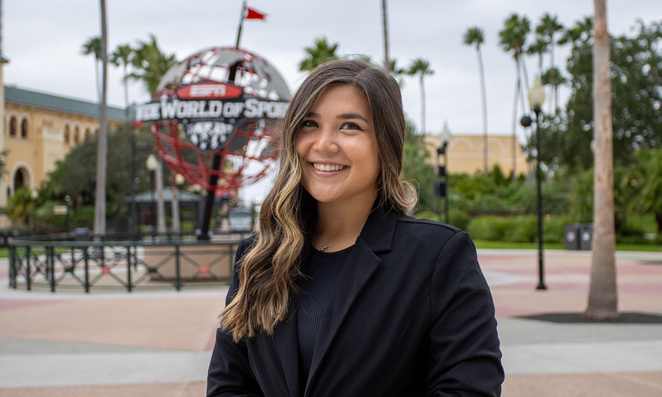 Jordan Hung poses for a photo in front of the ESPN Wide World of Sports.