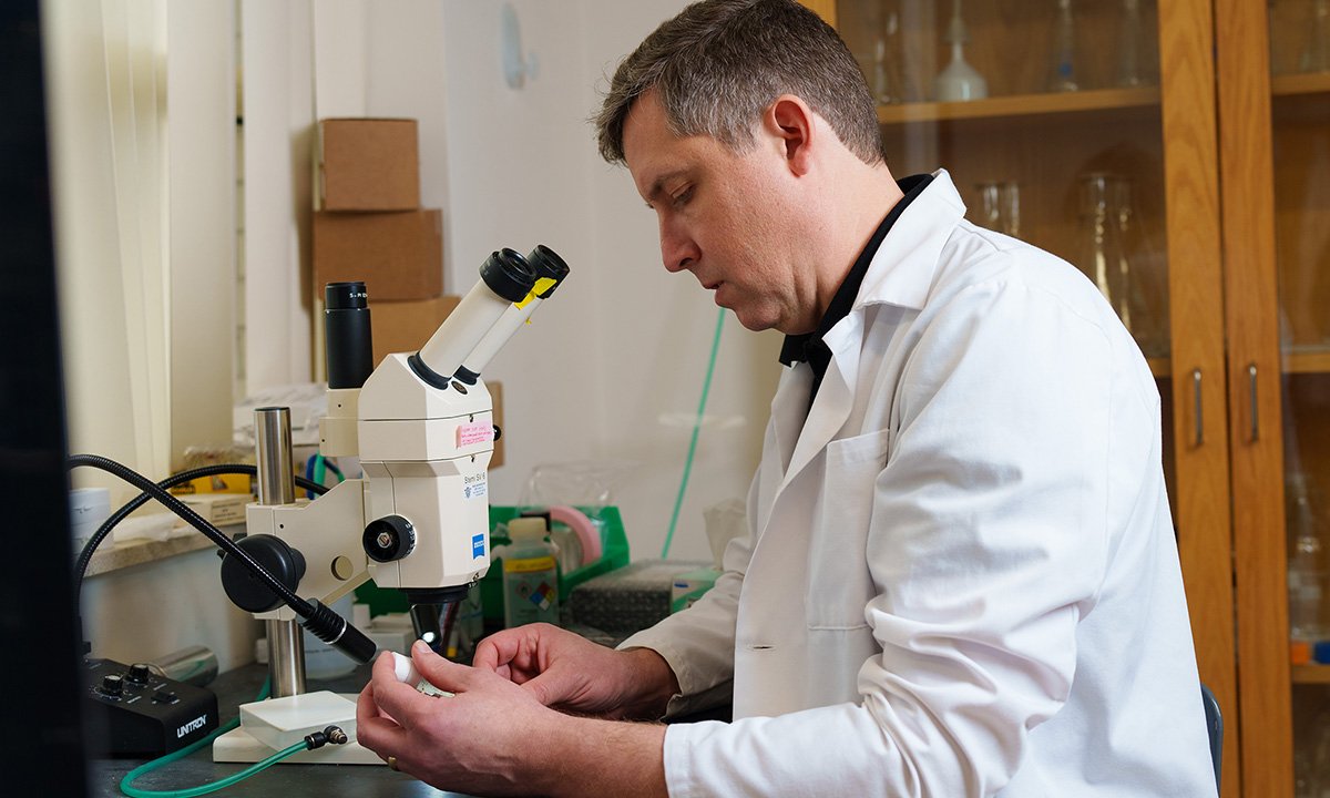 A man working on a microscope