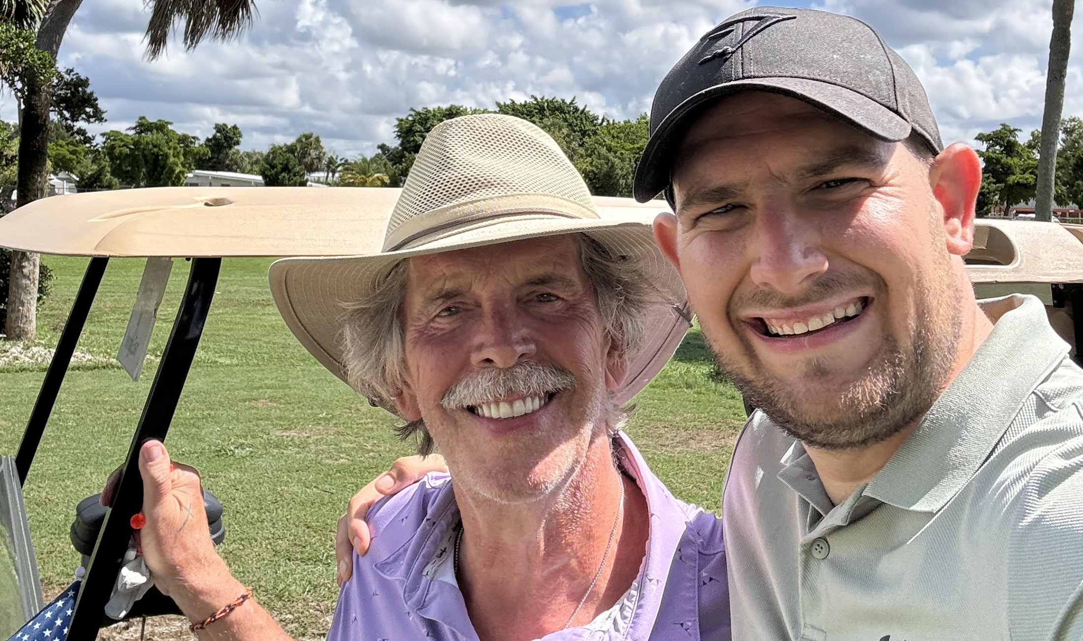 Joshua Hamann (right) poses for a photo with a man in a hat.