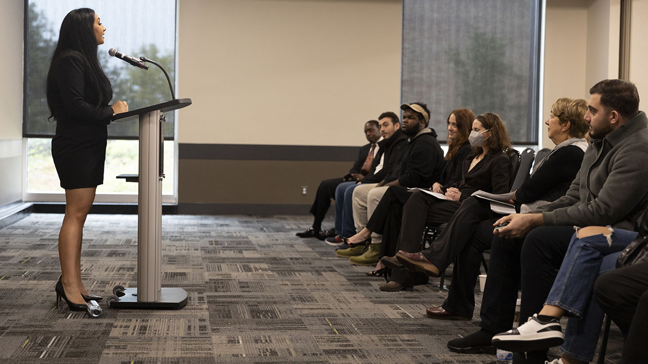 Mena Hannakachl speaks in front of an audience.