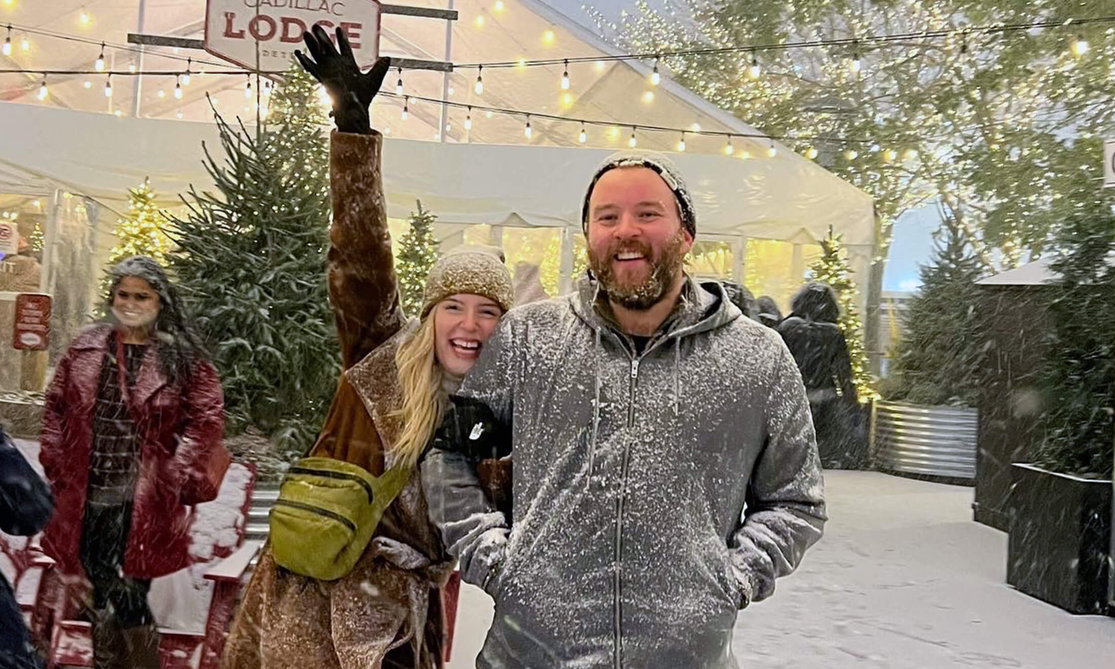 A man and woman smiling outside in downtown Detroit in the snow