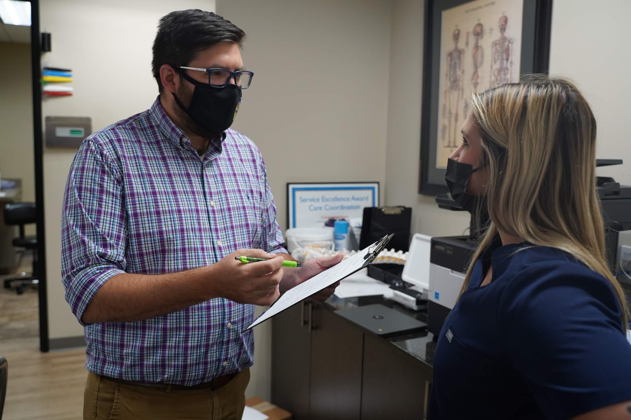 Michael Bonnette talks to a woman in medical scrubs.