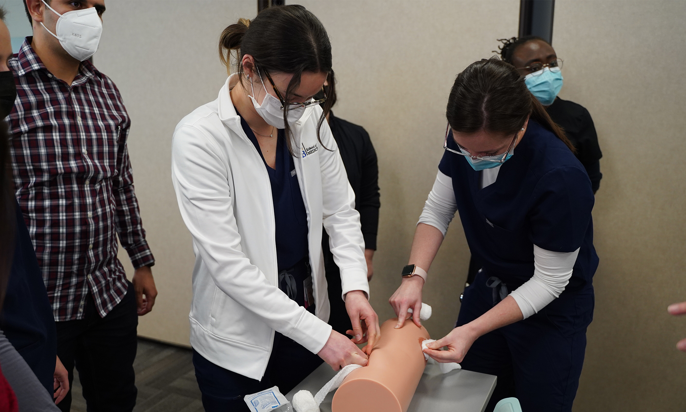 An image of students practicing stop the bleed.