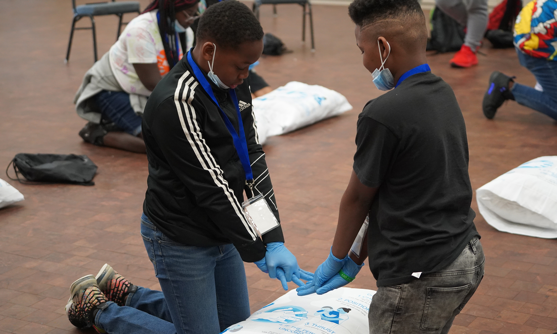 An image of two younger students training with the CPR pillowcase