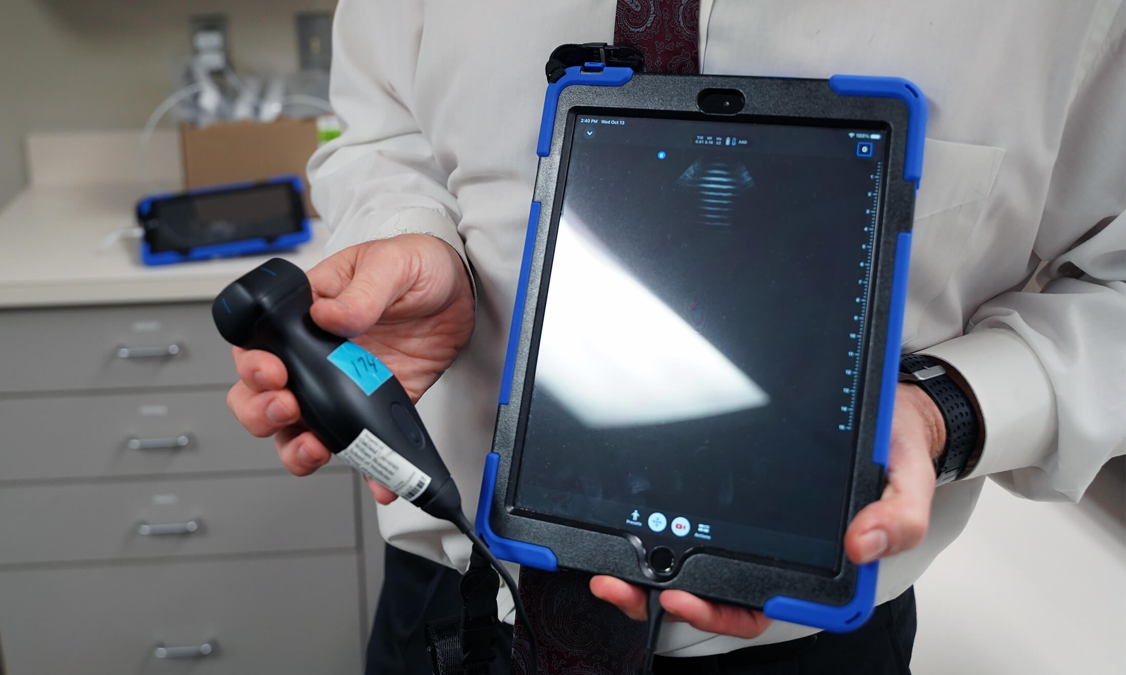 A person using a handheld ultrasound.