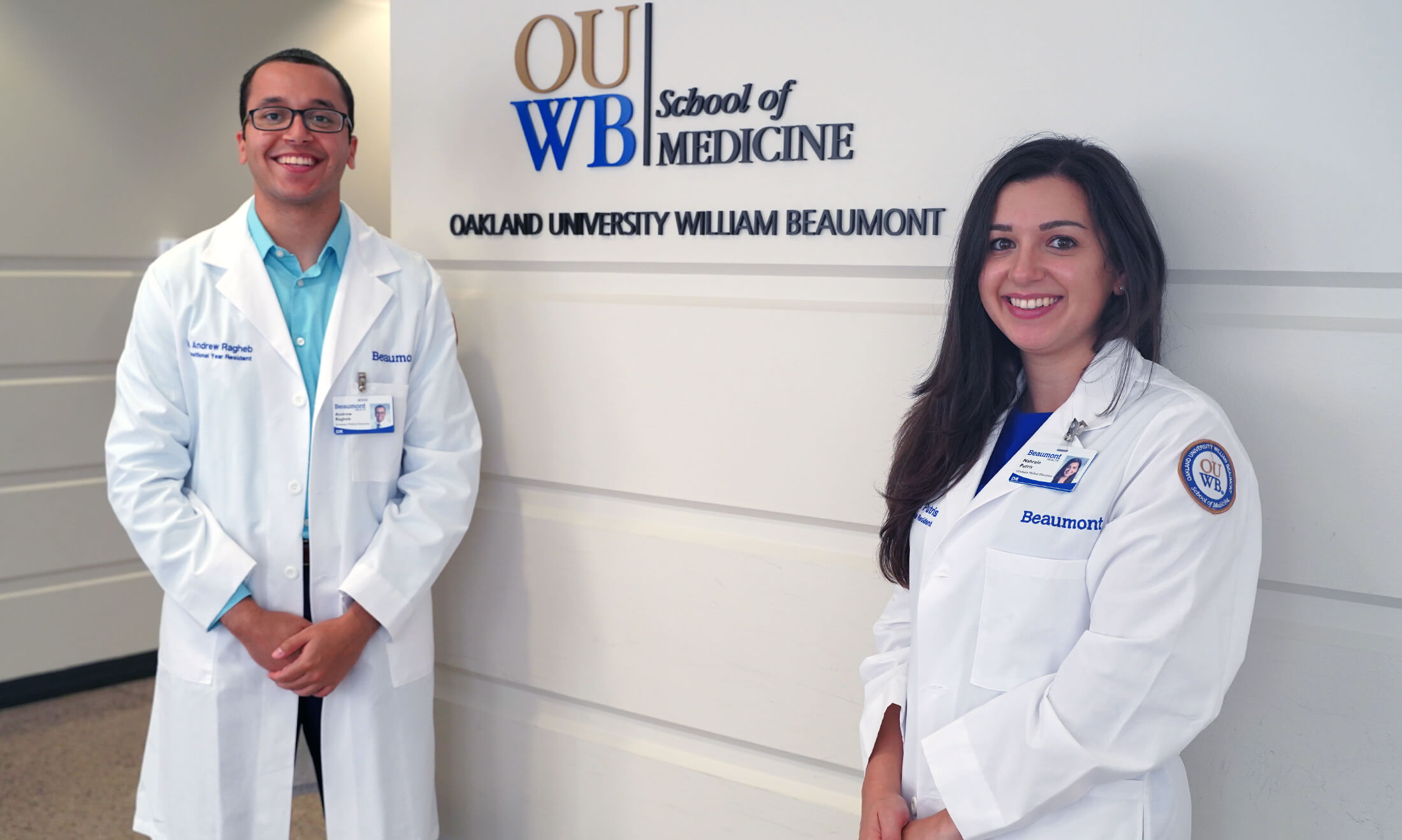 OUWB alumni posing in front of an OUWB sign.