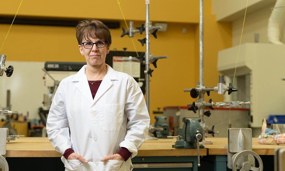 Woman wearing lab coat with hands in pockets