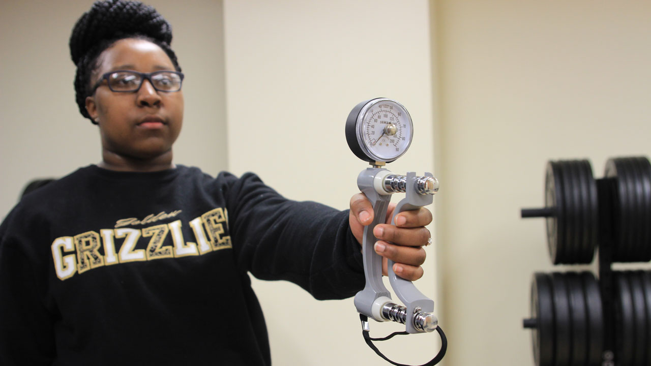 Artishia Moore holds a dynamometer.