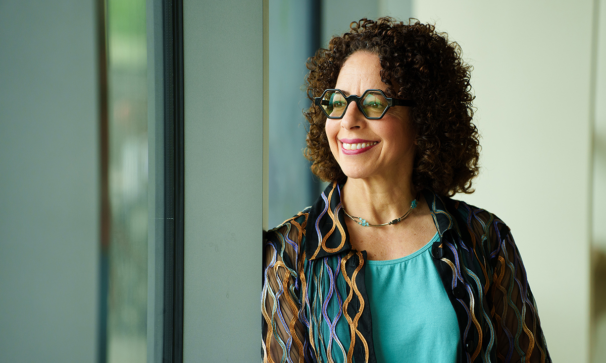 Dr. Florence Dallo smiles and gazes out a window into the distance