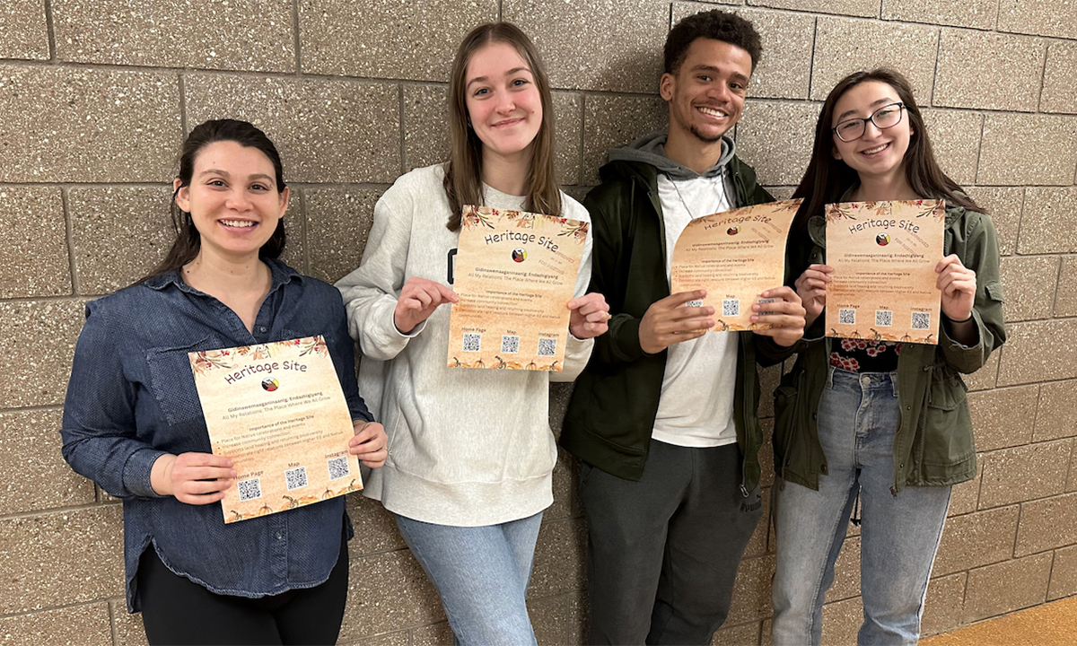 4 Eclipse students hold up flyers.