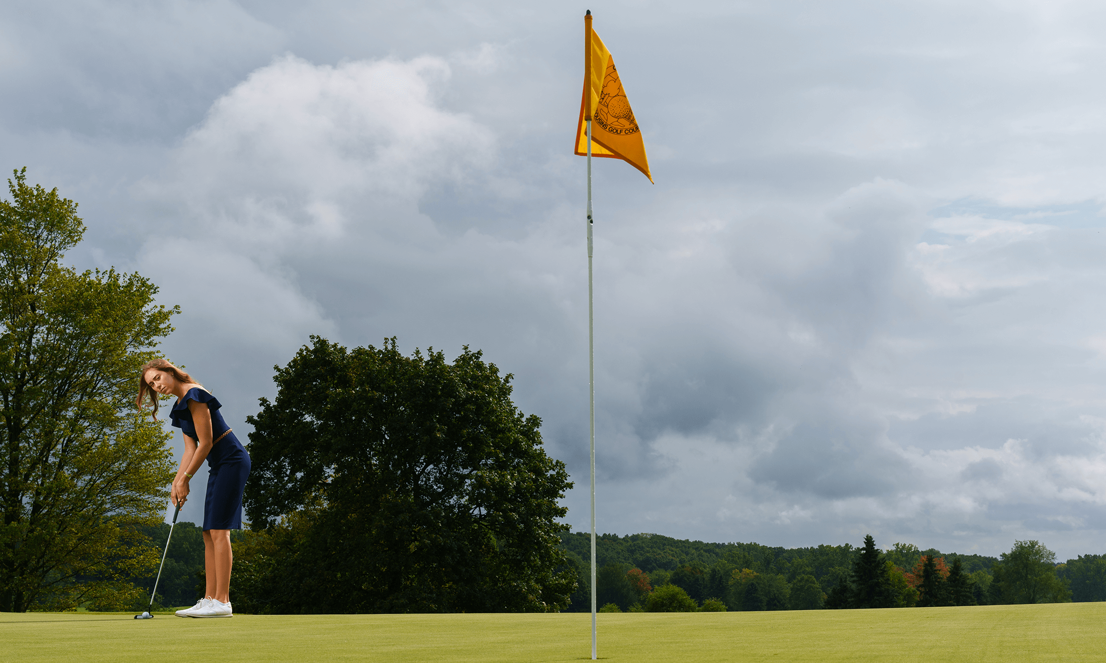 A woman puts on a golf course