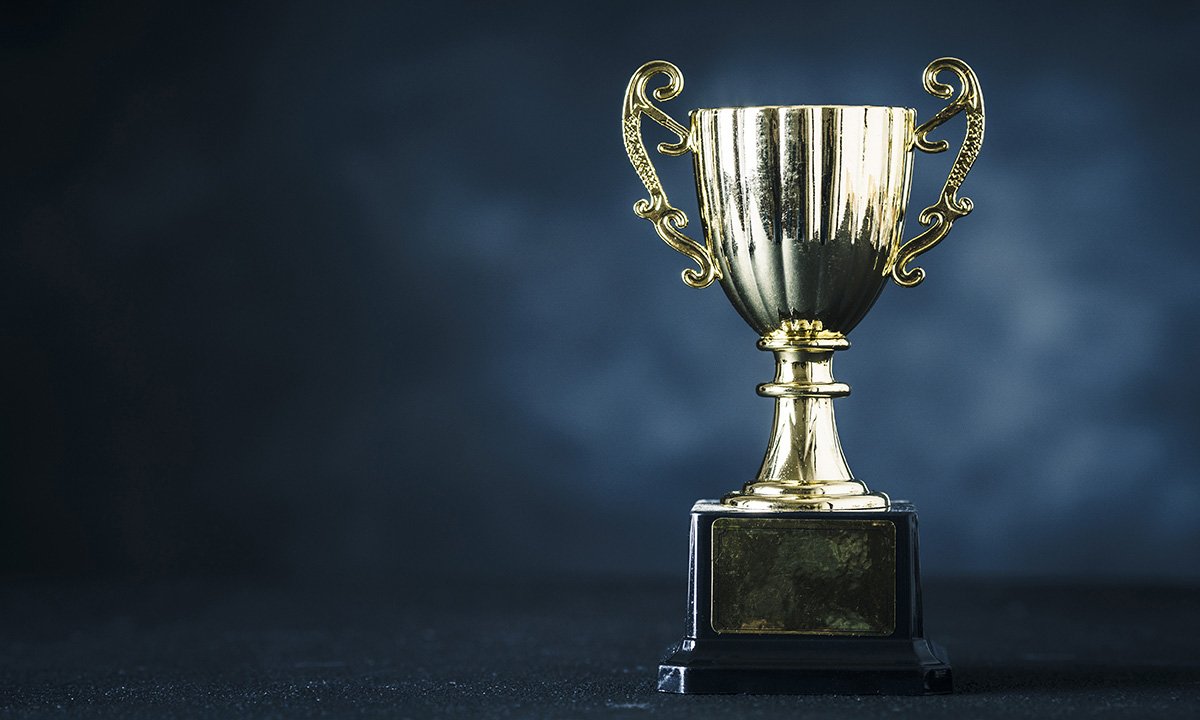 Silver trophy against blue backdrop.