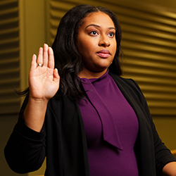 Woman with hand raise likes she's taking an oath.