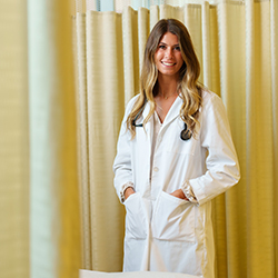 Woman in nursing uniform looks at the camera.