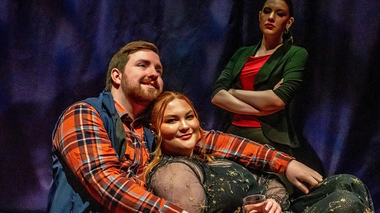 Photo of a couple cuddling, an angry-looking woman watches them