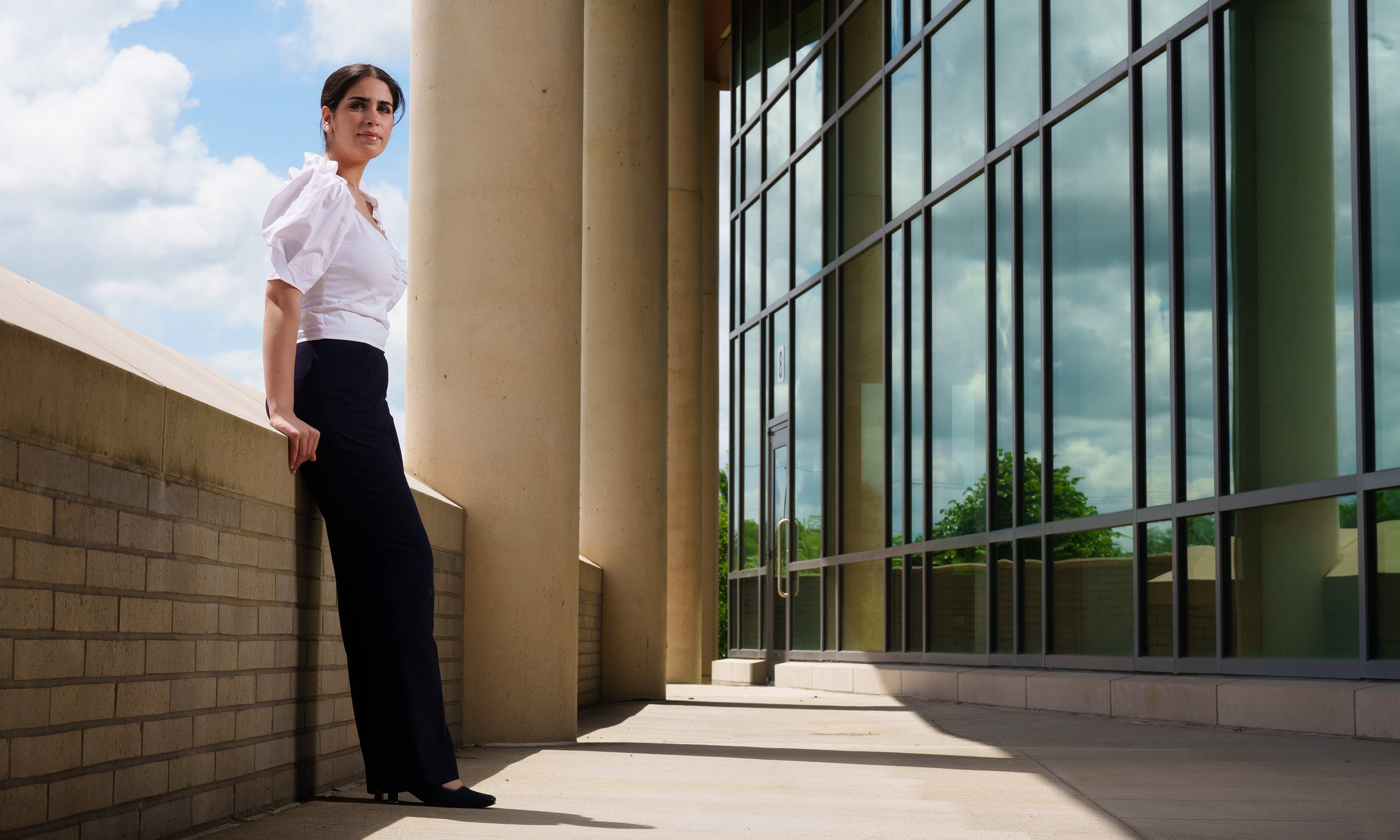 A student leaning on a wall outside