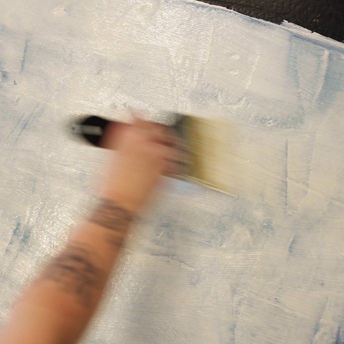 A hand holding a paintbrush