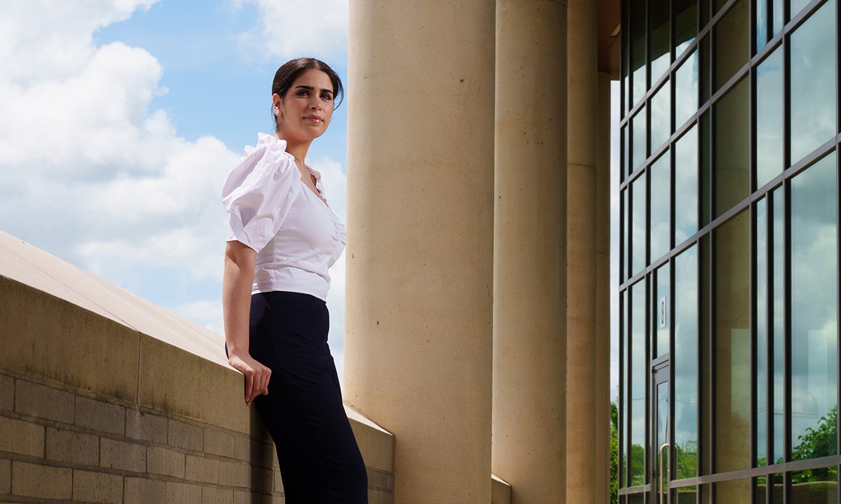 A student leaning on a wall outside