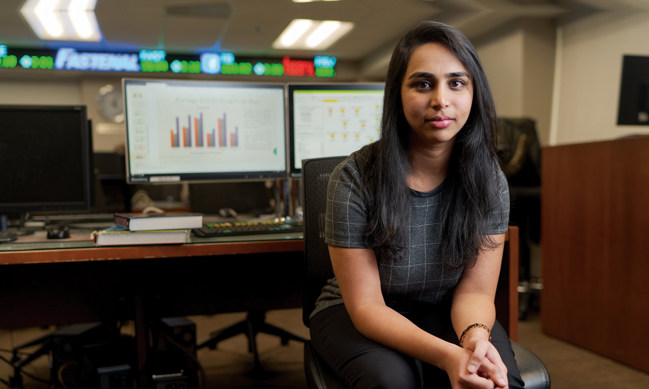 A woman sitting in front of computers.