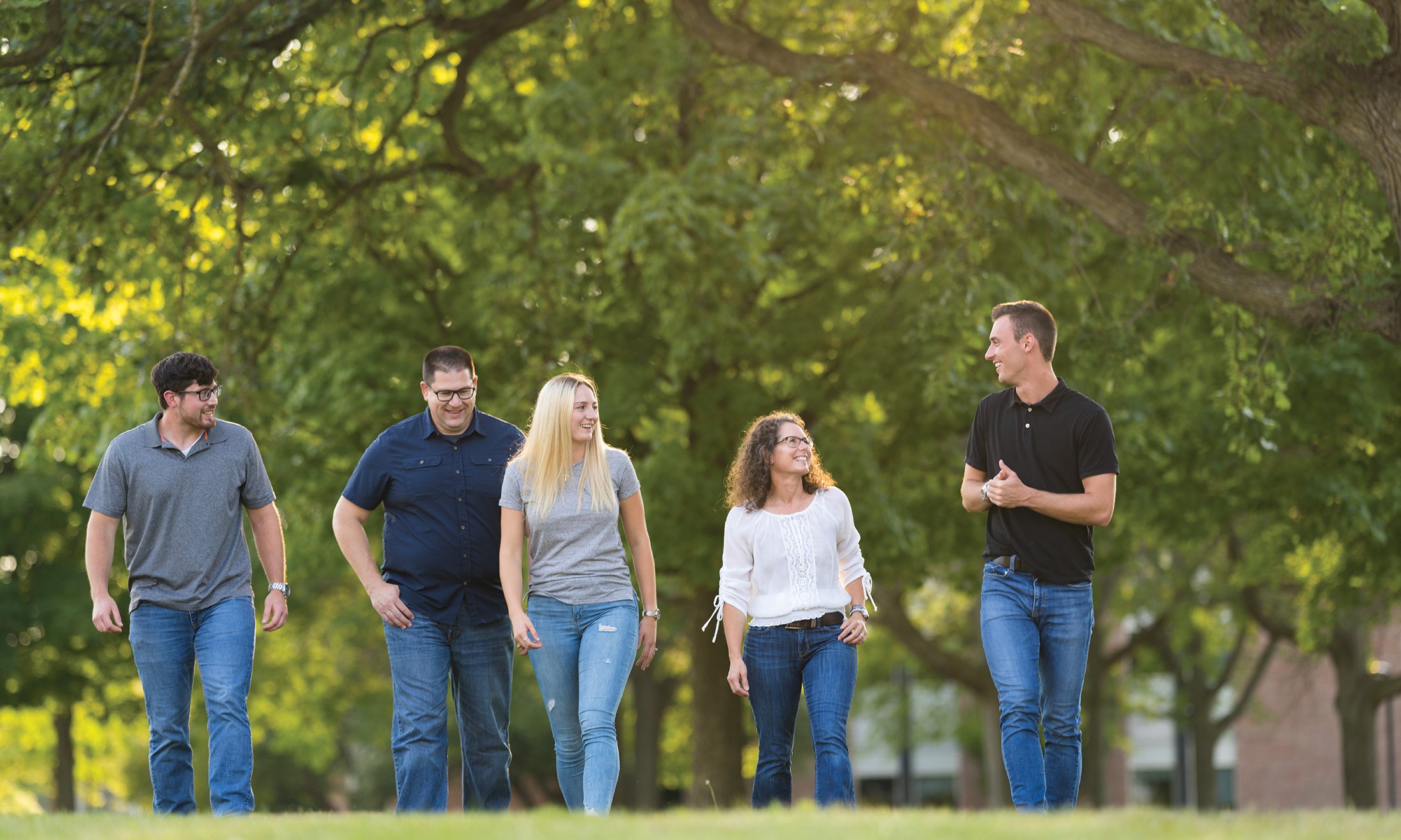 A group of five people walking outside.