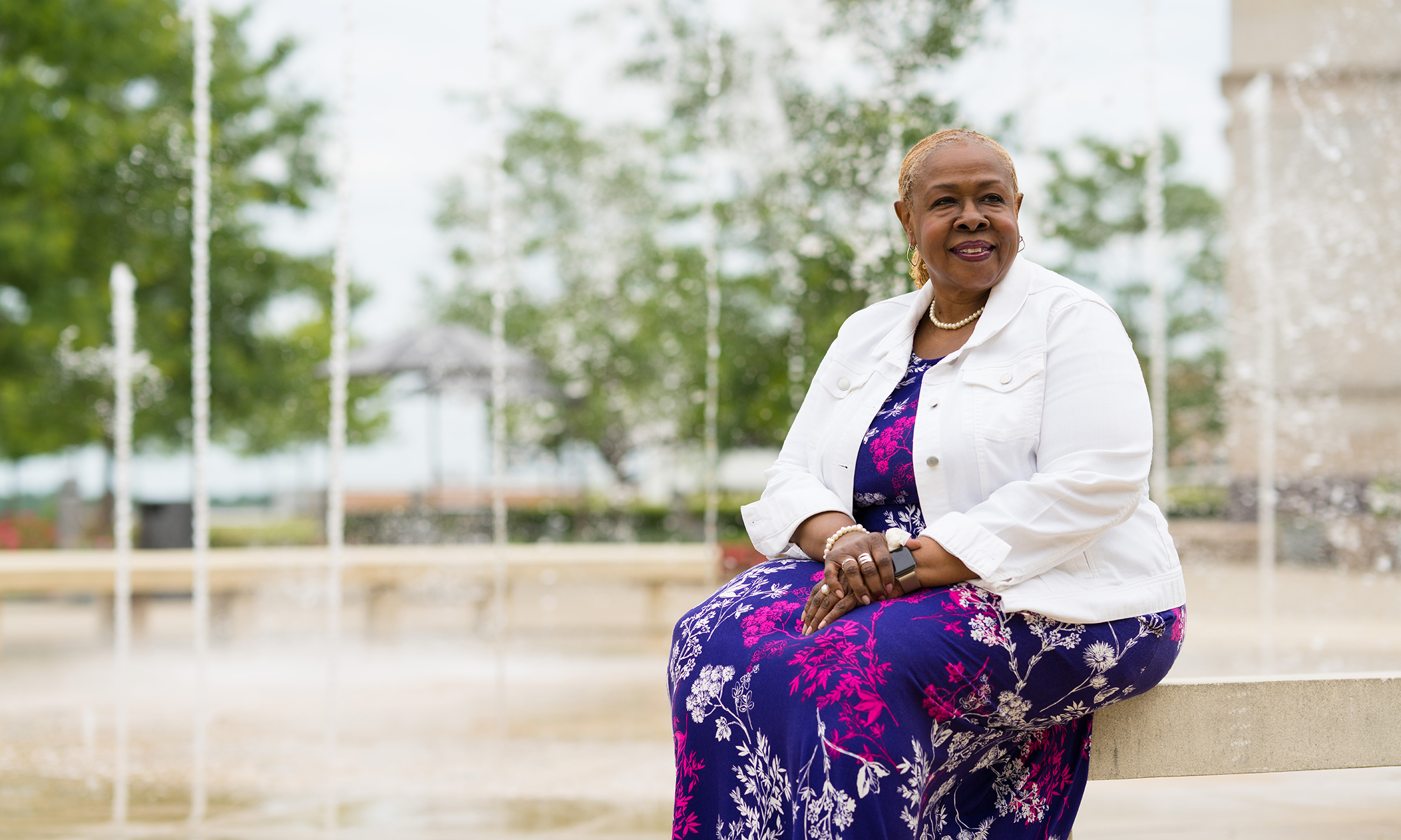 A woman sitting next to a fountain