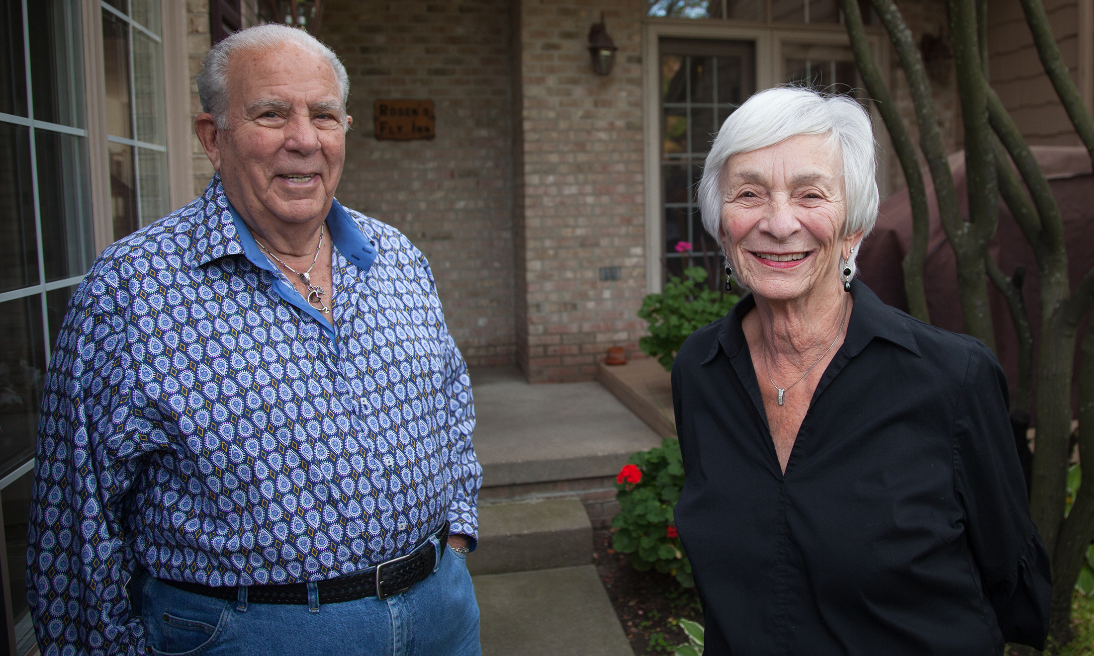 Two people standing outside their home