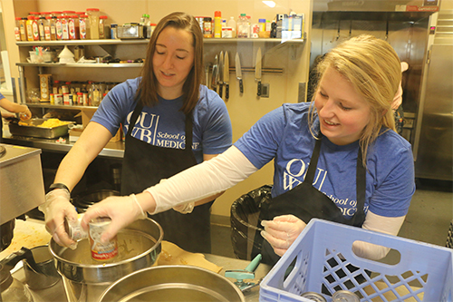 An image of two students cooking