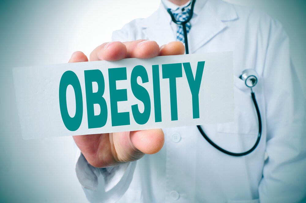 An image of a doctor holding a sign that reads obesity