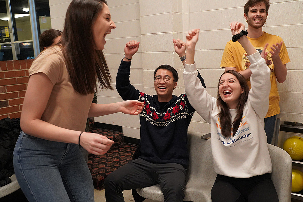 An image of students laughing while bowling
