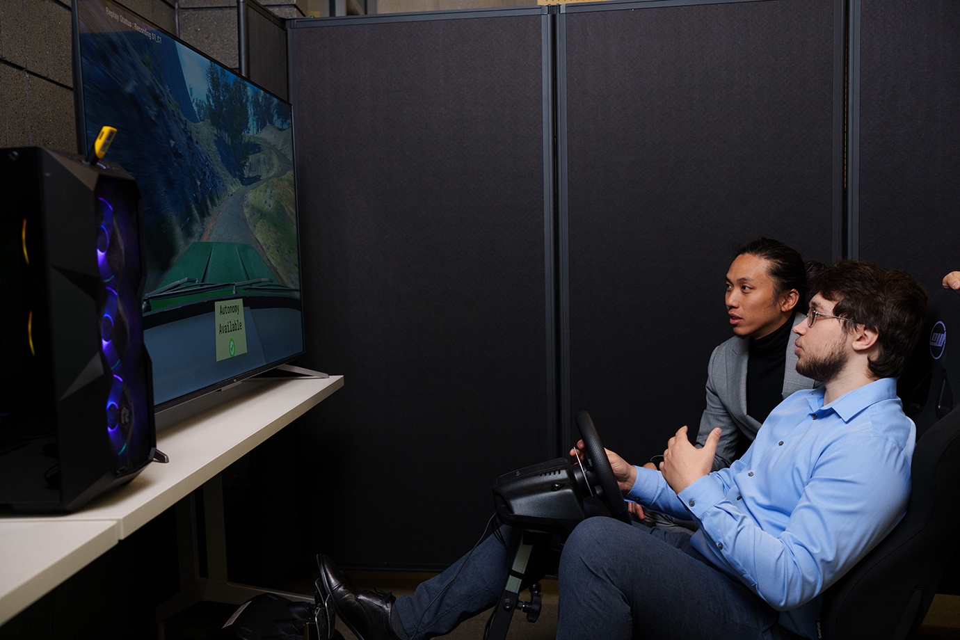 Two people using a driving simulator