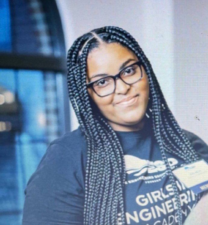 Woman in O U Engineering shirt smiles at the camera.