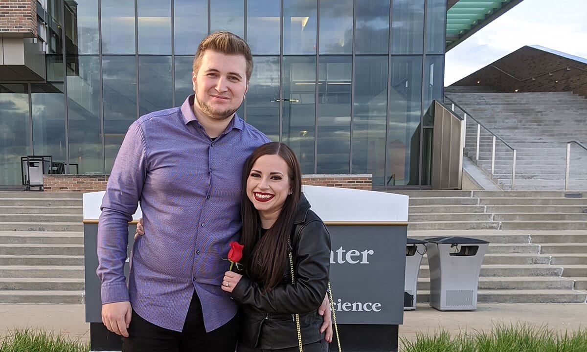 The engaged couple in front of the Engineering Center.