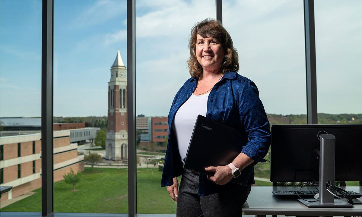 Woman standing in front of window with tower in background