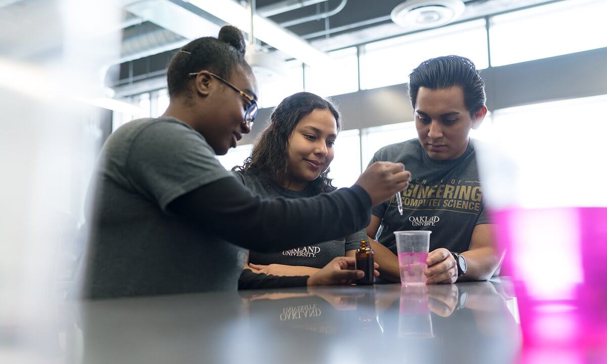 Three students doing a science experiment.