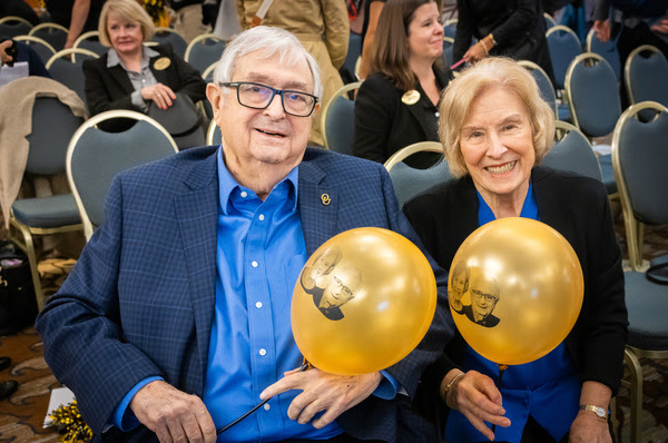 Donna and Walt Young Holding Golden Balloons