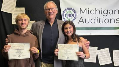 One Older person with his arms around two others holding up recognition papers
