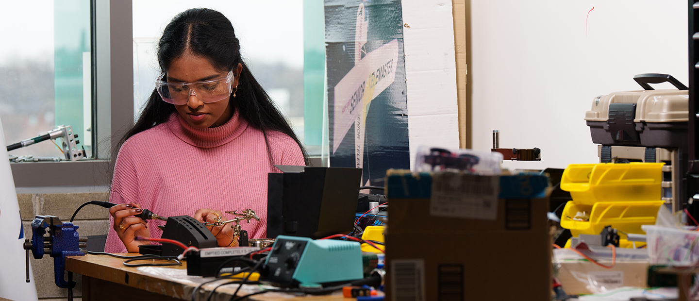 A young woman working on electrical equipment