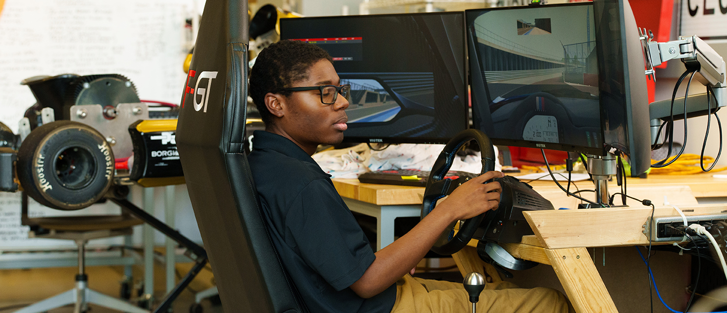 A student seated at a driving simulation