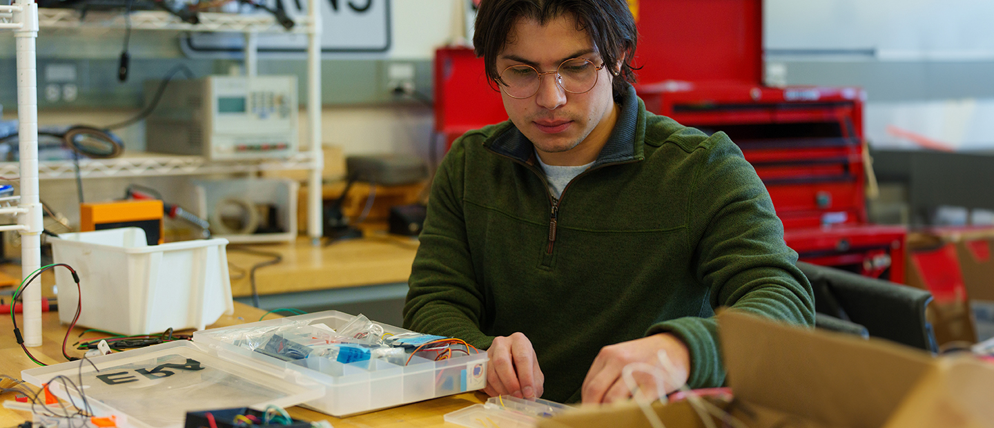 A student working in a lab with wires